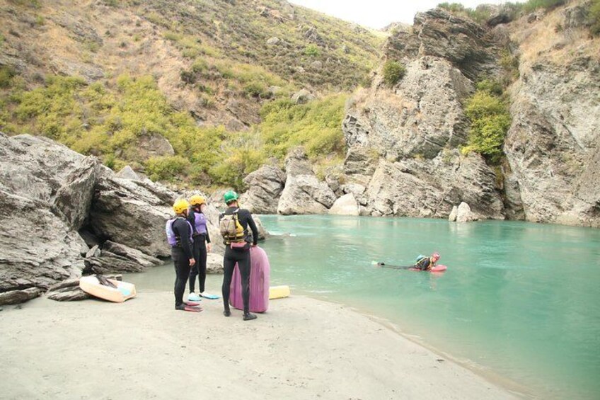 People on a beach with kayaks and a person in a kayak. 3