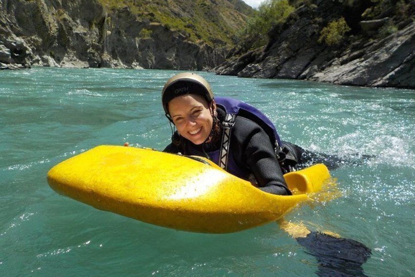 A person in a kayak on a river surrounded by rocky cliffs. 1