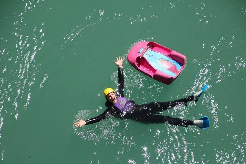 A person floating on water with a kayak nearby. 5