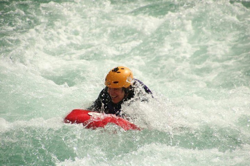 A person on a red kayak in rough water. 2