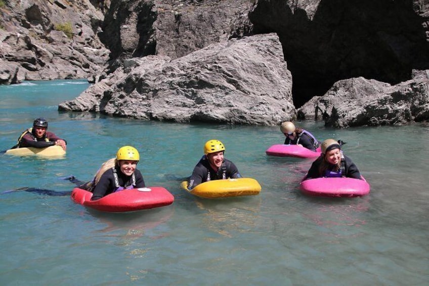 People kayaking on a river surrounded by rocks. 4