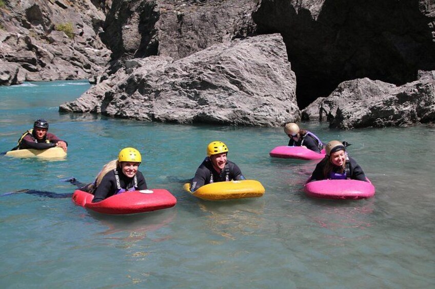 People kayaking on a river with rocky banks. 4
