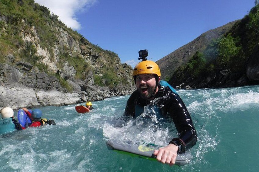 Una persona en una balsa, en un río rodeado de acantilados rocosos. 1