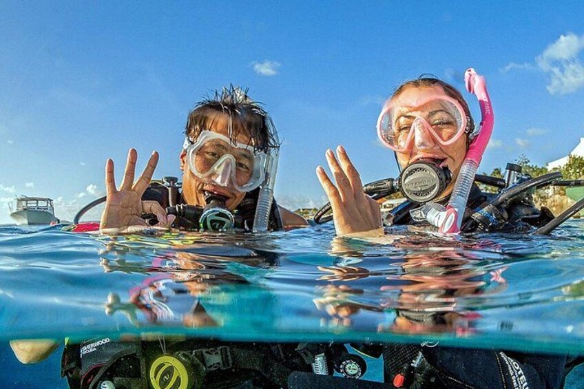 Two people snorkeling in clear blue water with a boat in the background. 5