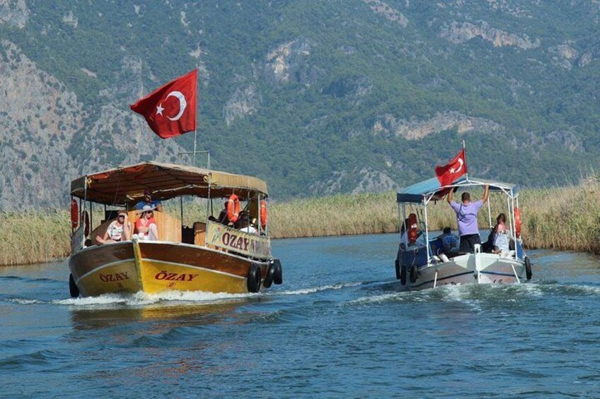 Two boats with Turkish flags on a river, surrounded by greenery. 3
