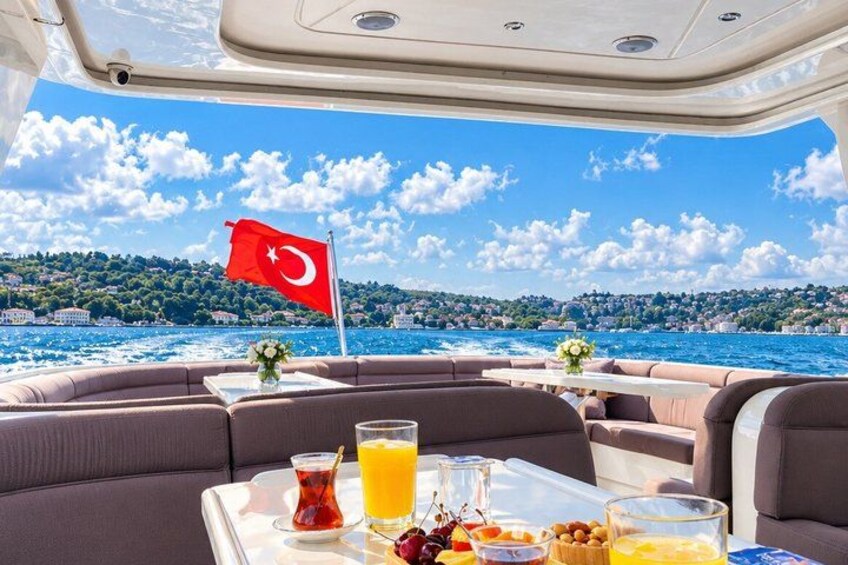 Een dek van een boot met een ontbijt gedekt, een Turkse vlag en een mooi uitzicht op de kustlijn. 5