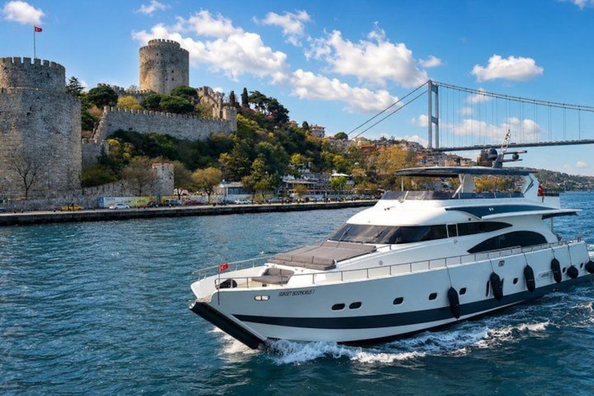 A white yacht on water with a castle and a bridge in the background. 3