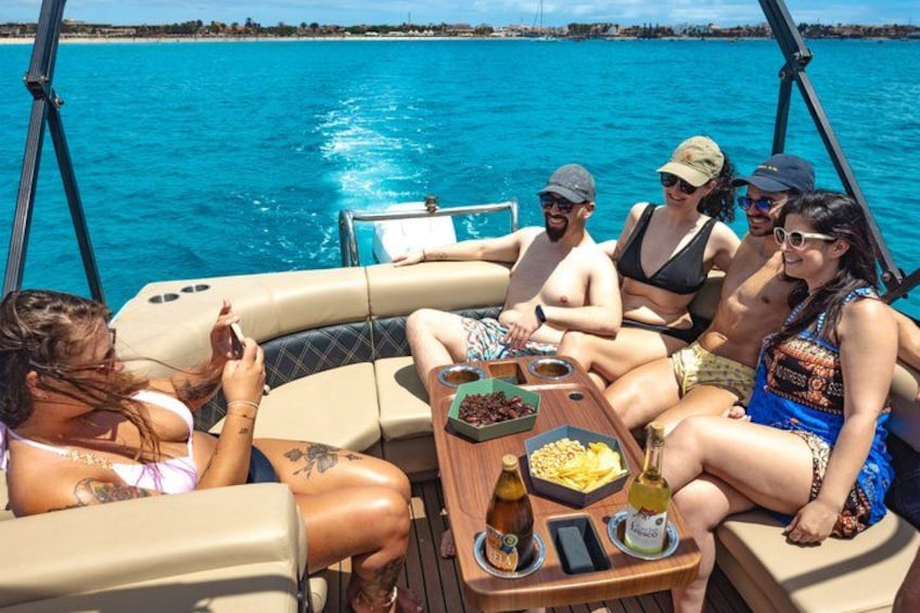 Eine Gruppe von Menschen auf einem Boot, im Vordergrund ein Tisch. 2