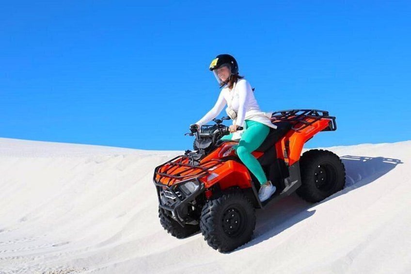A person riding an ATV on a snowy slope. 1