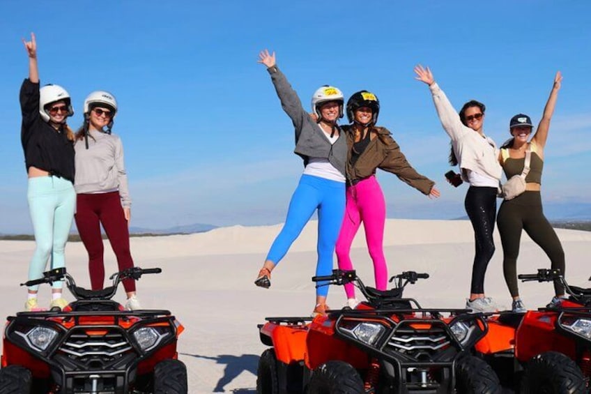 Eine Gruppe von Personen fährt mit Quads durch eine Wüstenlandschaft. 5