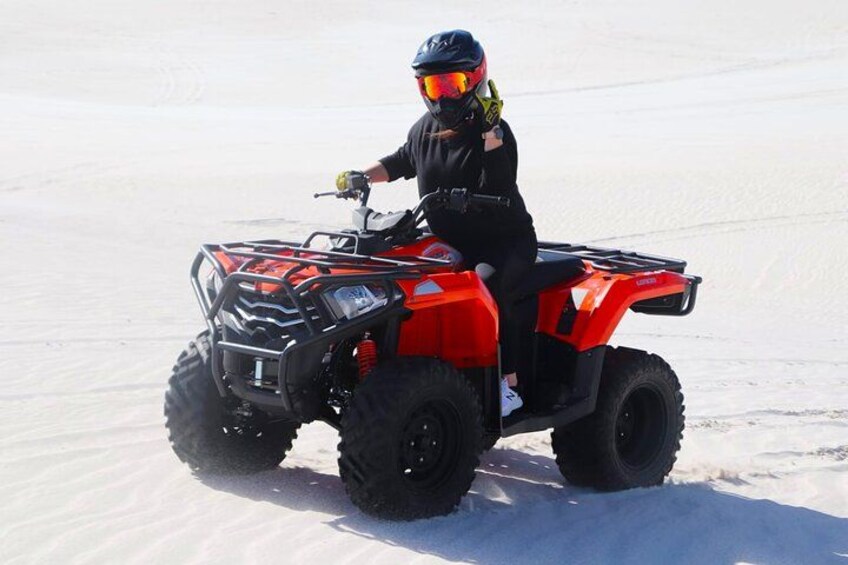 Eine Person fährt mit einem roten Quad über Schnee. 4