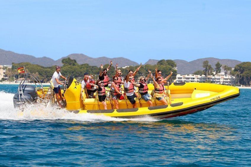 Un bote inflable amarillo con pasajeros navegando en un cuerpo de agua, rodeado de colinas y edificios. 1