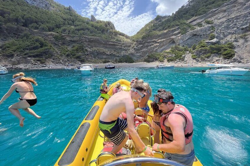 Un groupe de personnes sur un radeau gonflable jaune, sur une eau d’un bleu limpide, avec des collines rocheuses en arrière-plan. 3