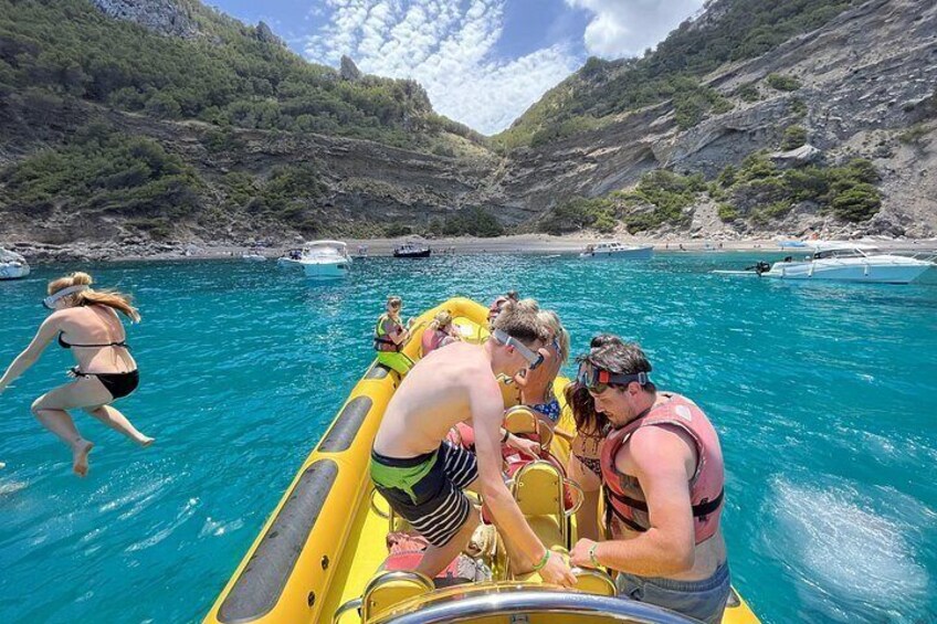 Un grupo de personas en un bote inflable amarillo en un mar turquesa, con colinas rocosas al fondo. 5