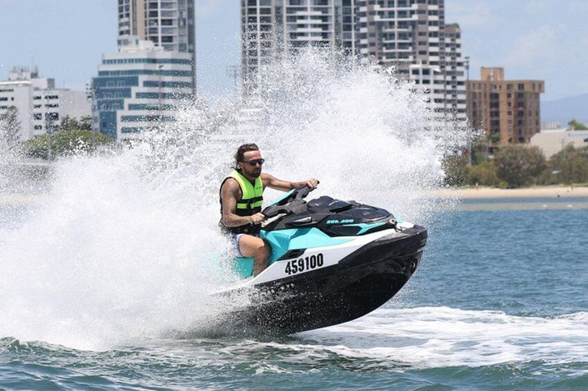 Iemand op een jetski op het water, met een stadsachtergrond. 3