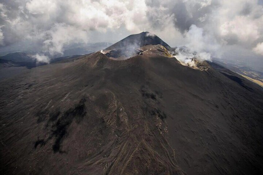 A volcanic landscape with a prominent peak emitting smoke. 5