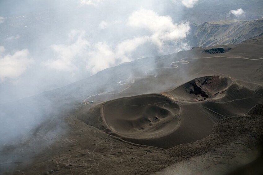 A vast desert landscape with undulating sand dunes and a winding road. 2