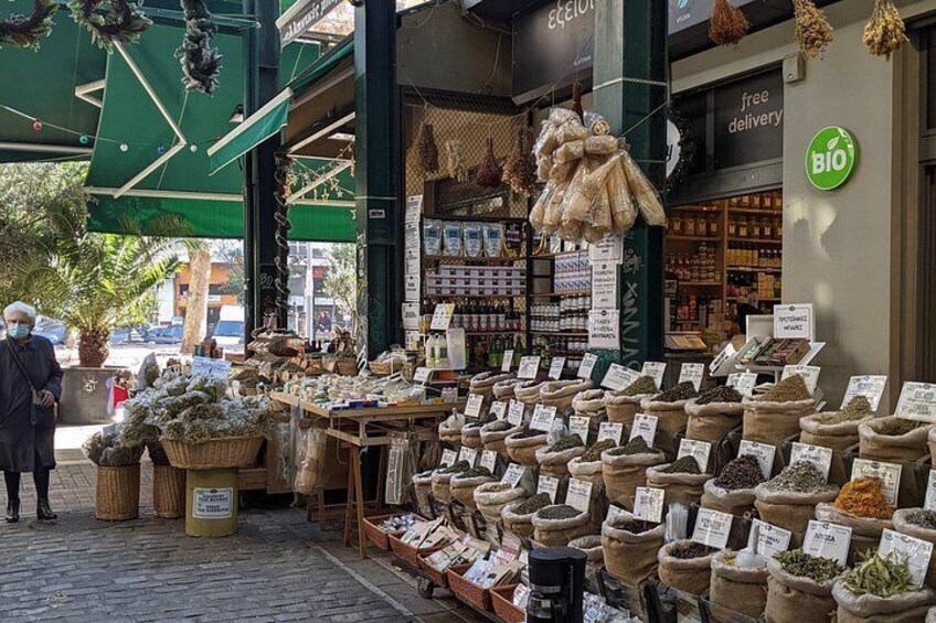 A street market with various stalls selling goods, including spices and dried plants. 4