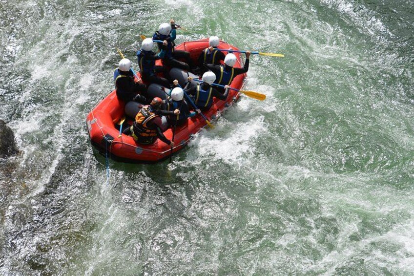 Un grupo de personas en una balsa roja navegando por un río. 5