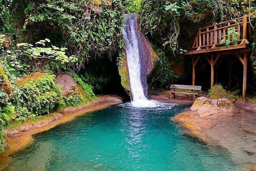 A waterfall, a wooden bench, and a wooden structure. 2