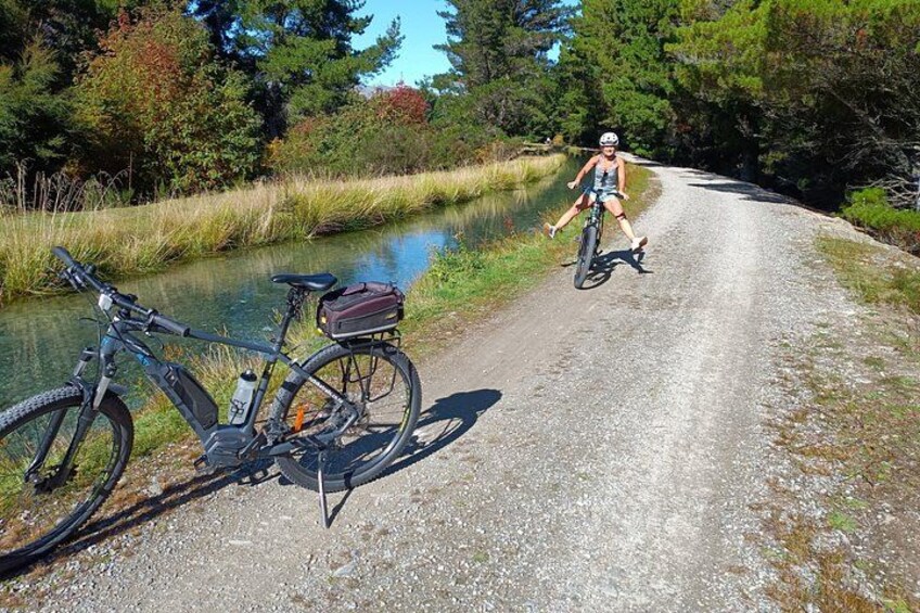 A gravel path, a bicycle, and a person riding the bicycle. 3