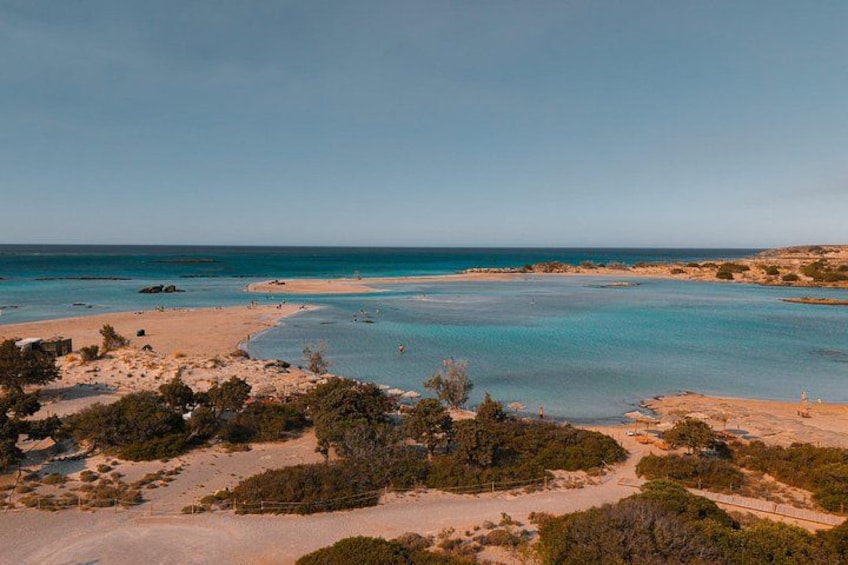 A coastal landscape with clear blue waters, sandy beaches, and sparse vegetation. 3