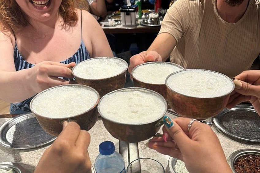 People holding large bowls of a white substance, possibly food, in a casual setting. 2