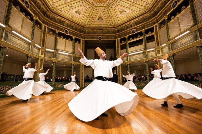 A dance performance in a grand hall with ornate architecture and a polished wooden floor. 1