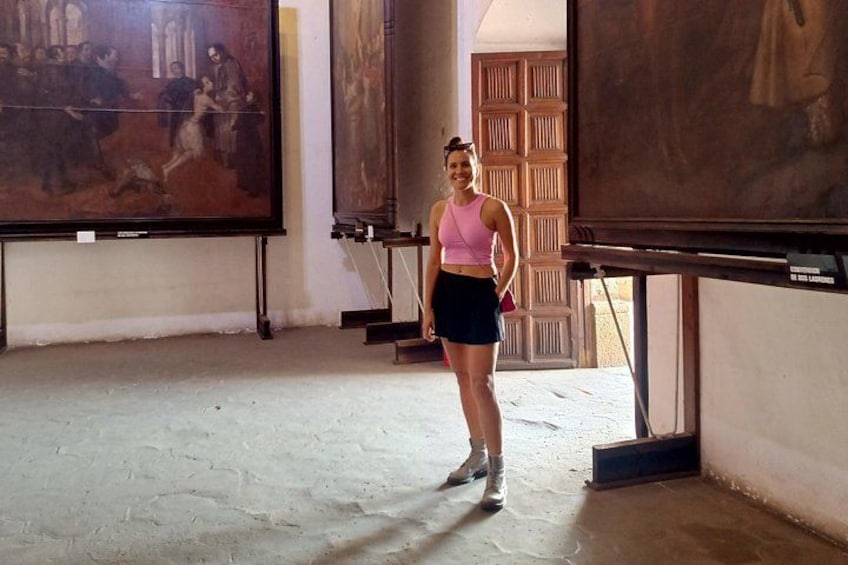 A person standing in an art gallery with paintings on the walls. 3