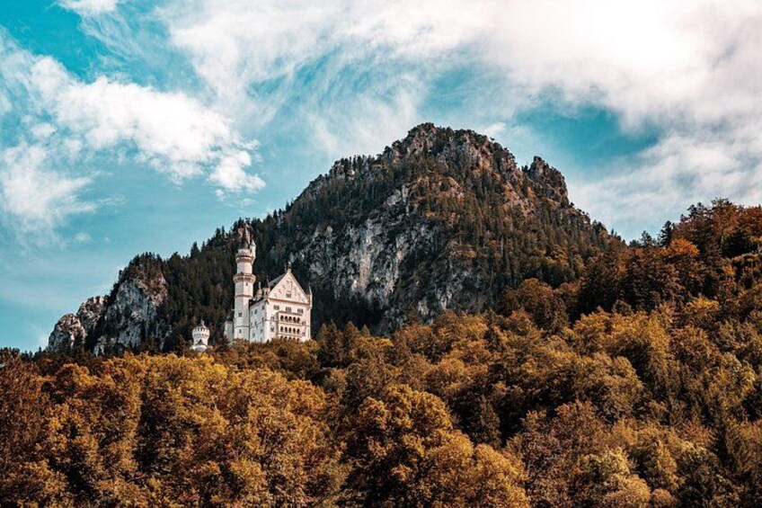 Un château perché sur une colline, entouré d’un feuillage automnal. 3