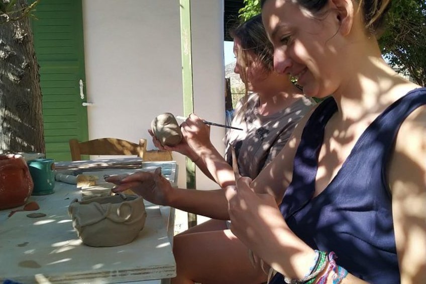 Una persona pintando una maceta de cerámica. 5