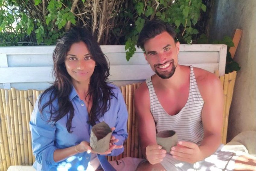 Dos personas sentadas en un banco al aire libre, sosteniendo tazas. 2