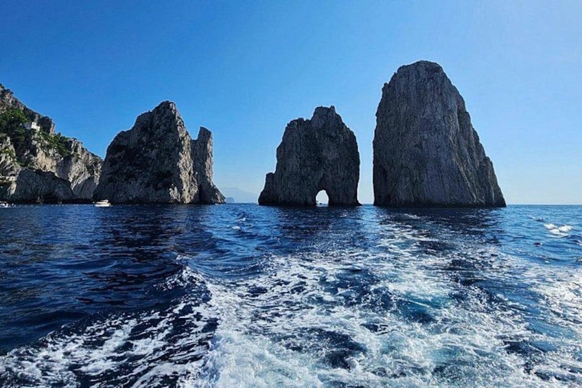 A coastal landscape with two prominent rock formations and a clear blue sky. 4