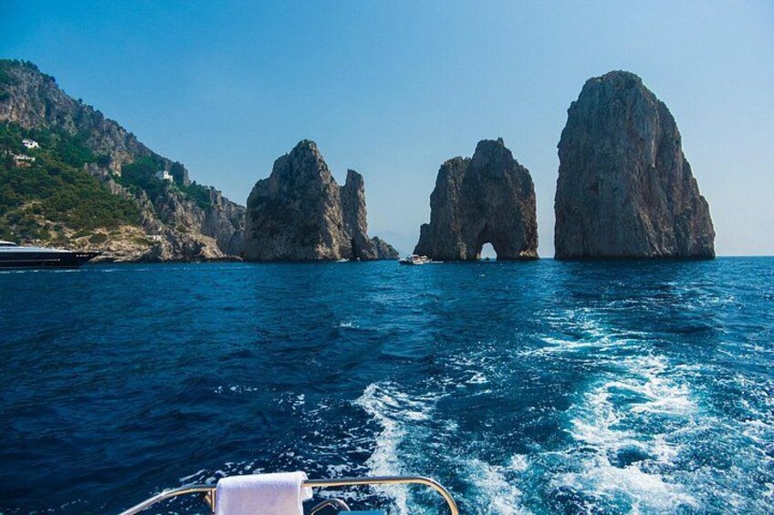 A boat on the water with two large rock formations in the background. 3