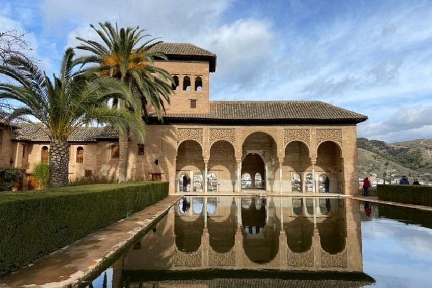 A historic building with arches and a reflective pool. 3