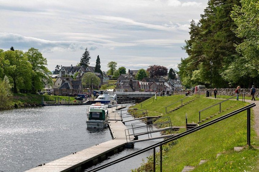 A river with boats, a dock, and houses in the background. 2