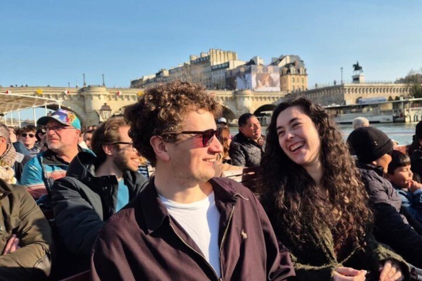 A crowd of people near a historic building with a river in the background. 4