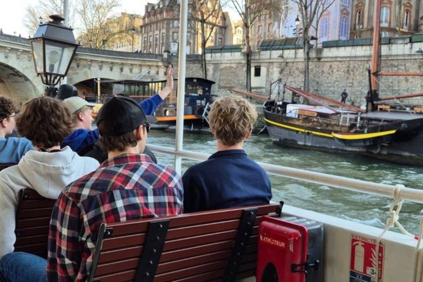 People on a boat, a river, and a bridge in the background. 3