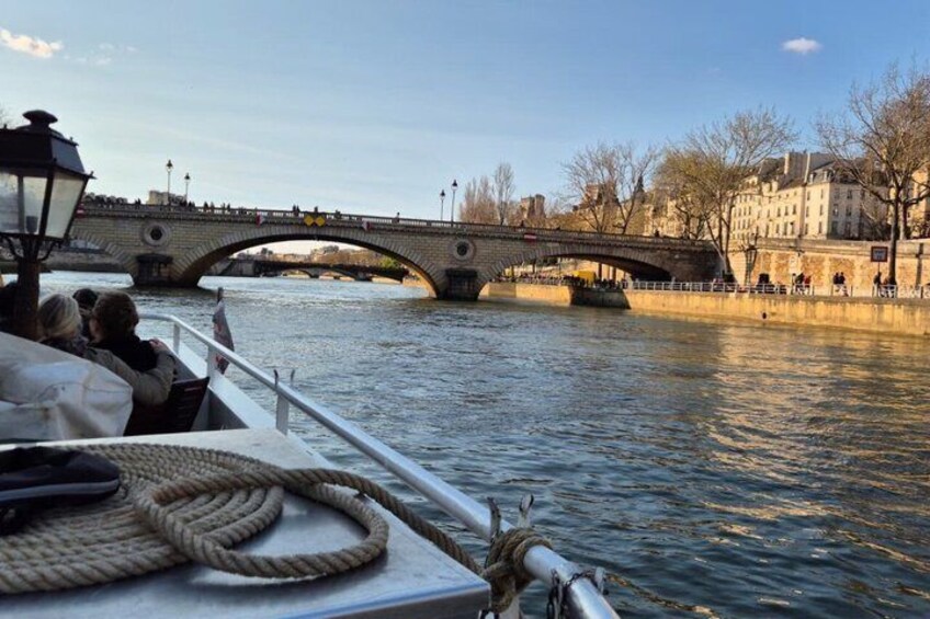 A boat on a river with a stone bridge in the background. 3