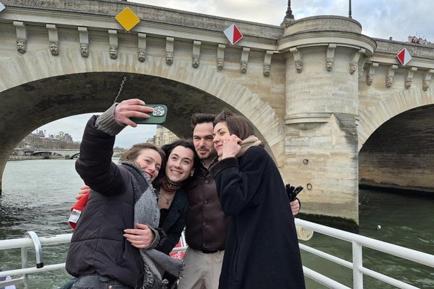 A group of people taking a selfie under a stone bridge with a river in the background. 5