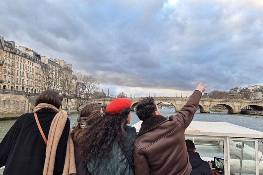 A group of people on a boat, a river, and a bridge in the background. 4