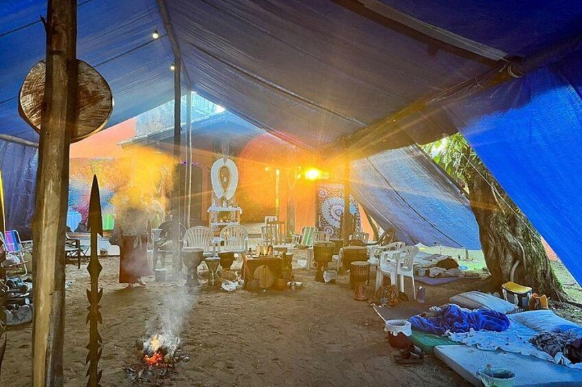 Una tenda con un fuoco, attrezzature da cucina e un'area pranzo. 3
