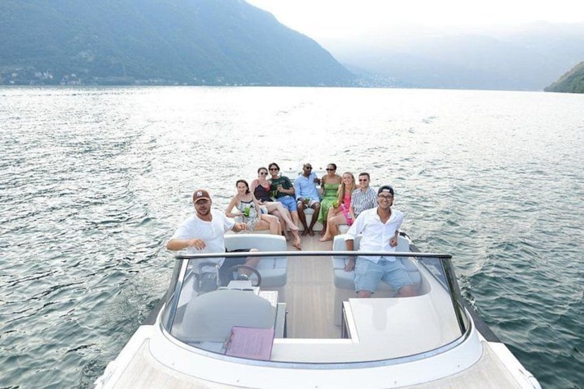 A group of people on a boat with a lake and mountains in the background. 2