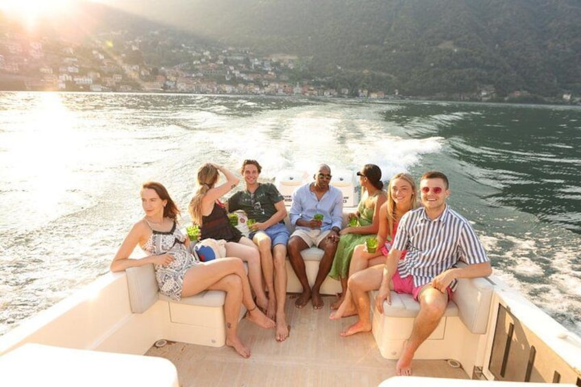 A group of people on a boat with a body of water and a distant shoreline in the background. 4