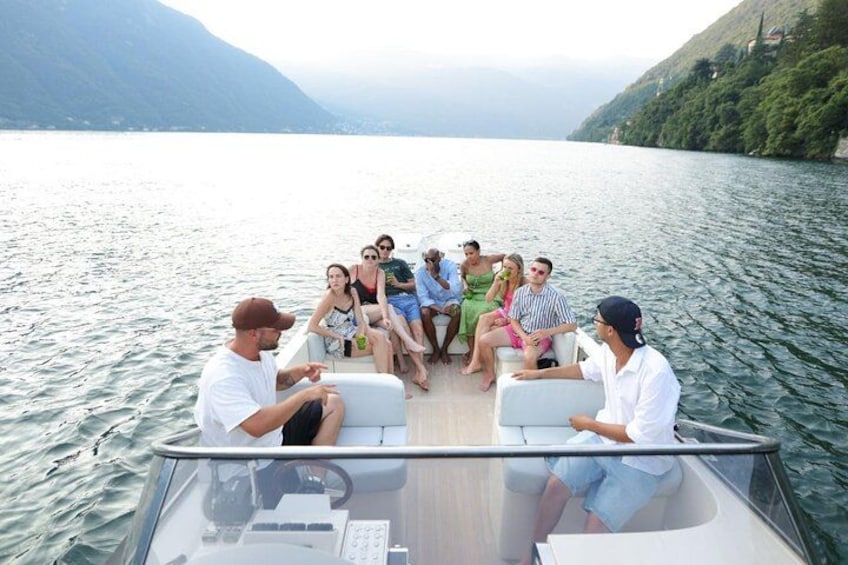 A group of people on a boat with a lake and mountains in the background. 3