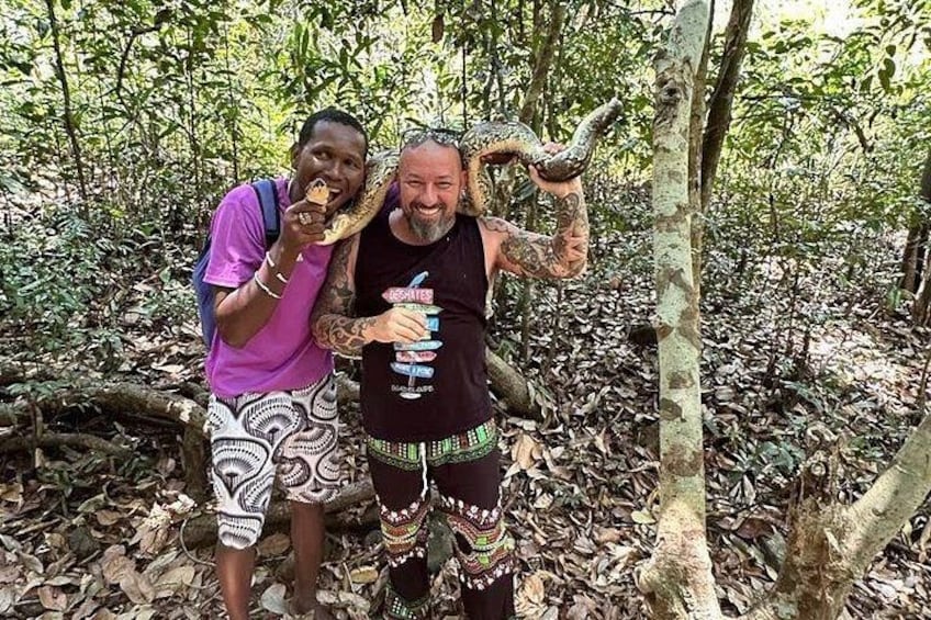 Dos personas en un bosque con una serpiente grande. 1