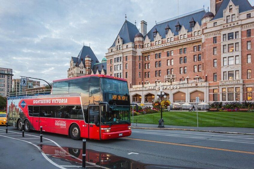 A red double-decker bus labeled 'Sightseeing Victoria' on a city street. 4