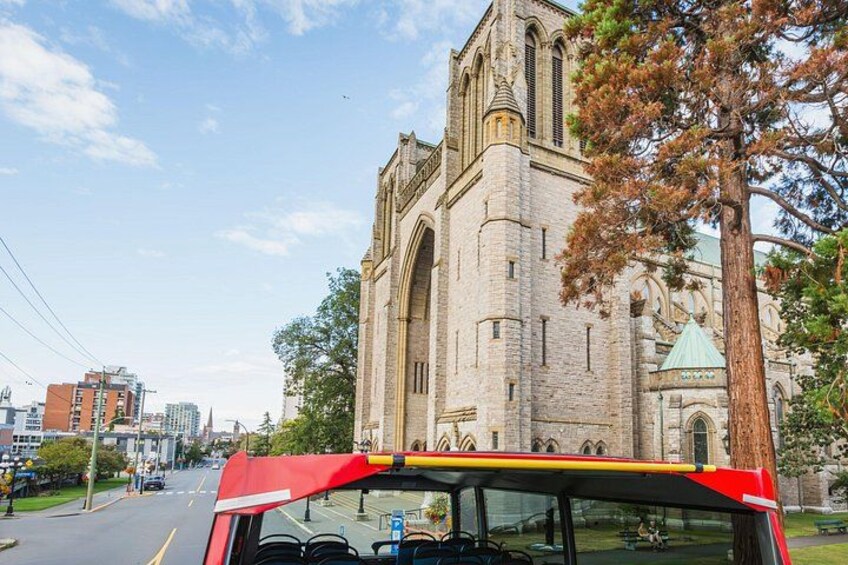A red bus in front of a large brick building with a green dome. 2