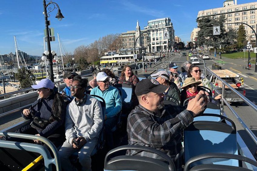 A group of people on a sightseeing boat, a bridge, and buildings in the background. 3