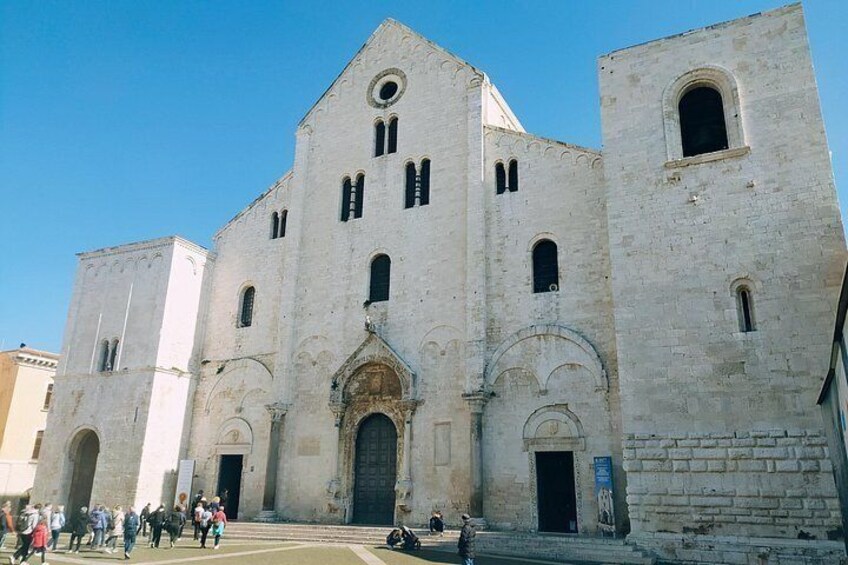 Un edificio storico con un grande arco centrale, un campanile e una torre più piccola a destra. 3